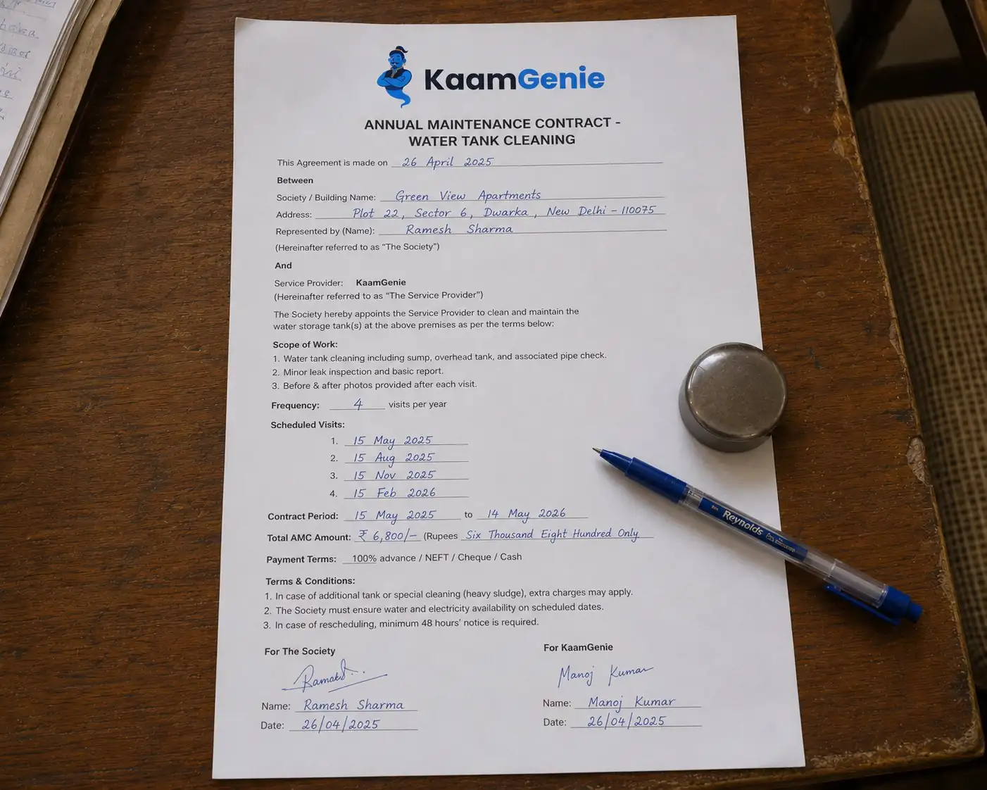 A signed Annual Maintenance Contract for water tank cleaning on a wooden desk - showing four visits per year, society details, and signatures - the paperwork that locks in 20 percent savings for RWAs