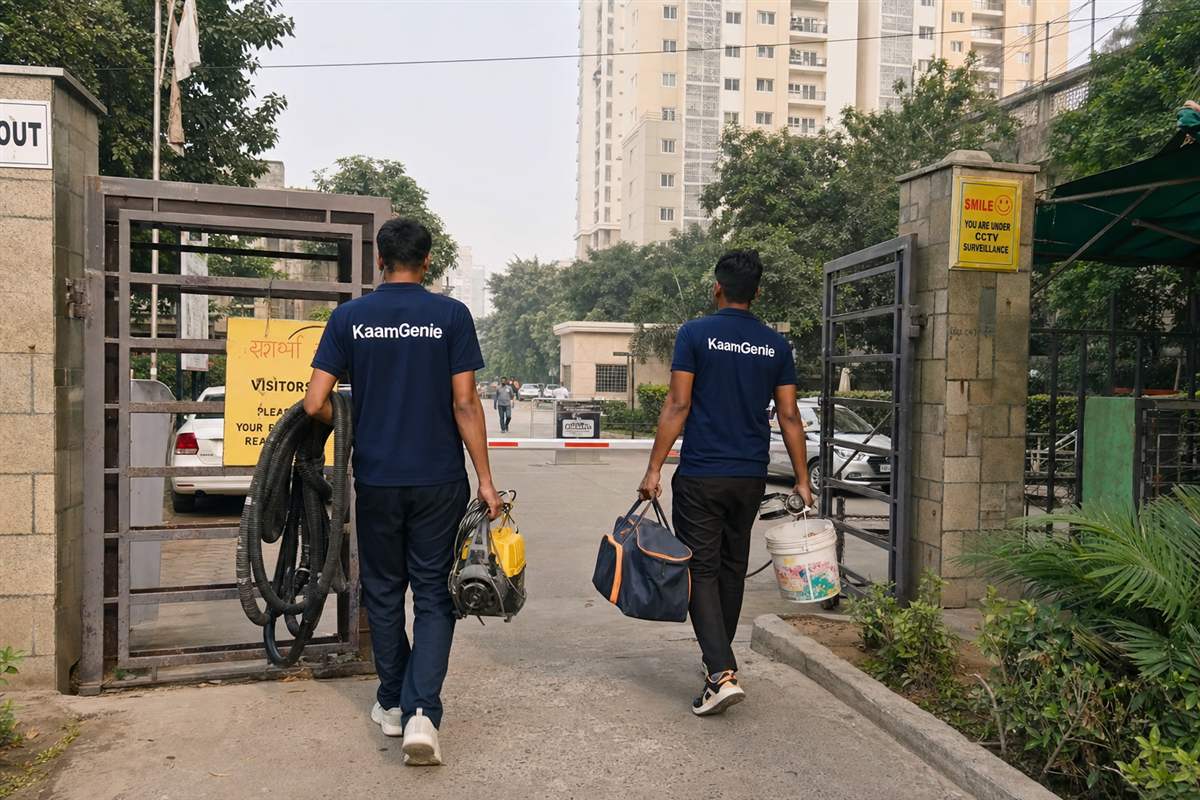 A navy KaamGenie crew of two arriving at a Noida society for a professional water tank cleaning, equipment in hand
