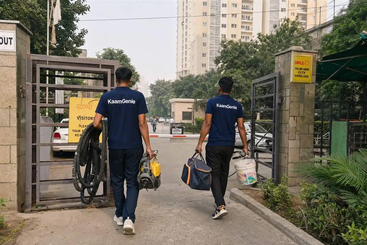 A navy KaamGenie crew of two arriving at a Noida society for a professional water tank cleaning, equipment in hand