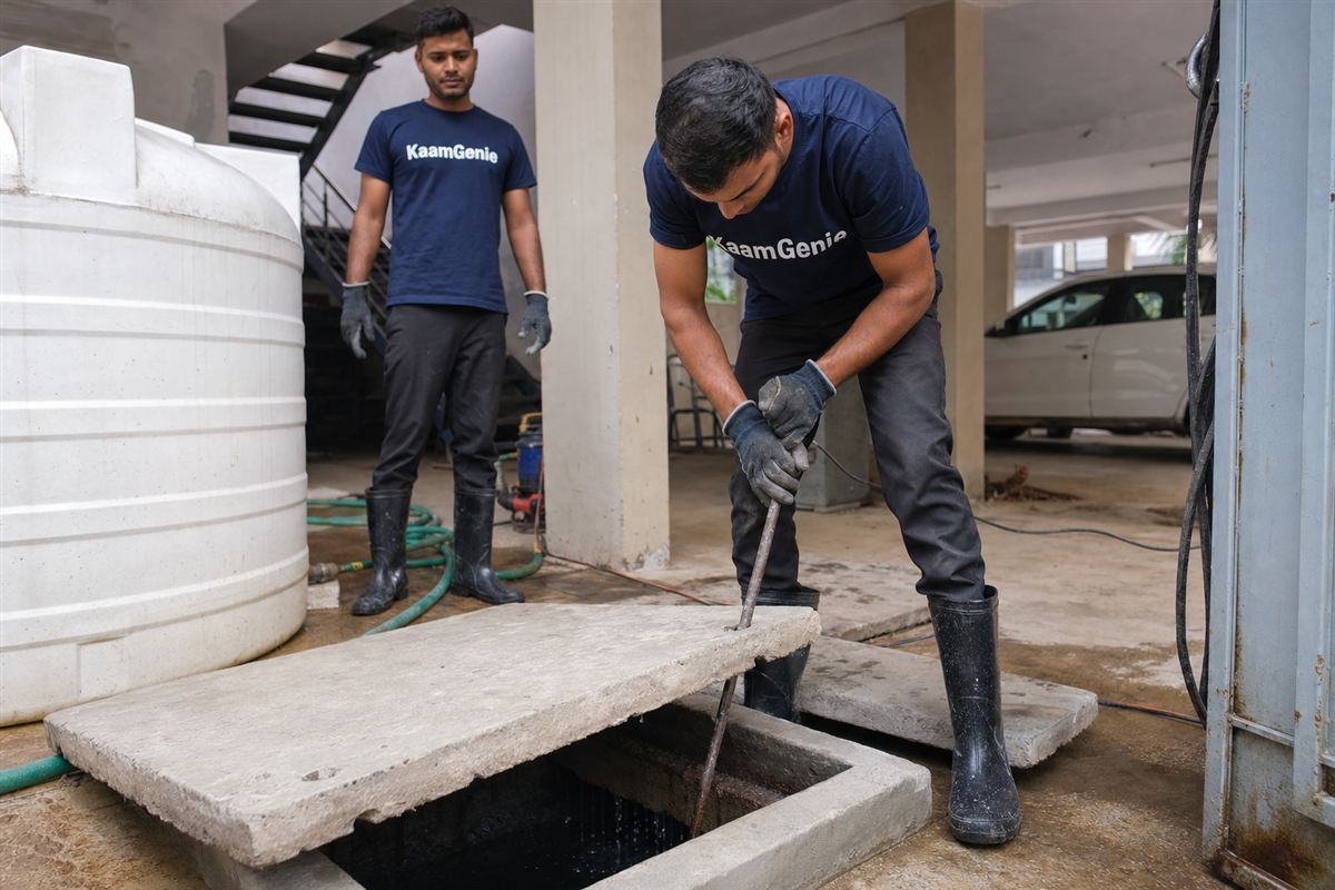 KaamGenie crew cleaning several rooftop water tanks side by side on a Gurgaon builder-floor terrace in a single visit