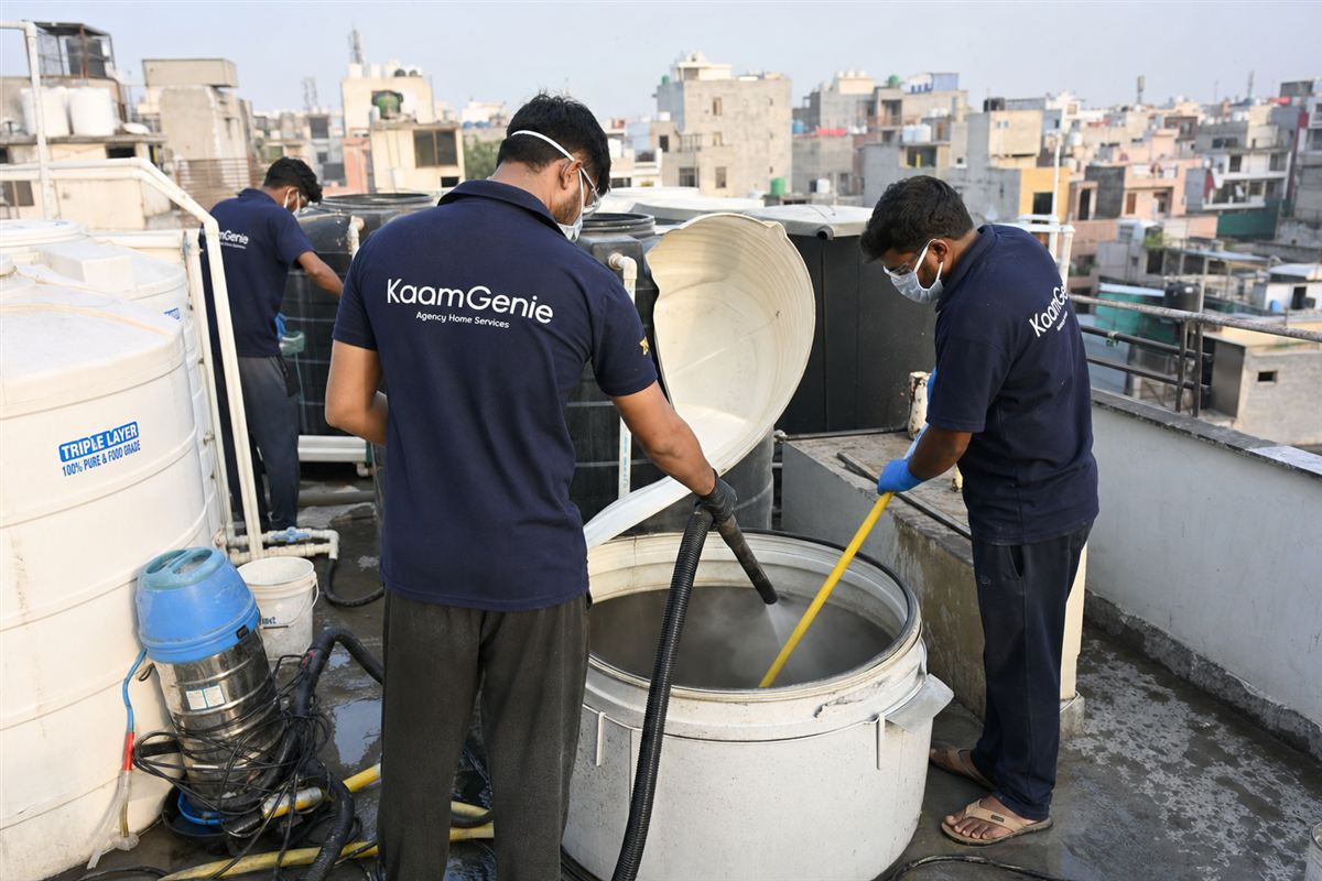 KaamGenie crew cleaning the shared rooftop tank of an independent builder floor building in Delhi