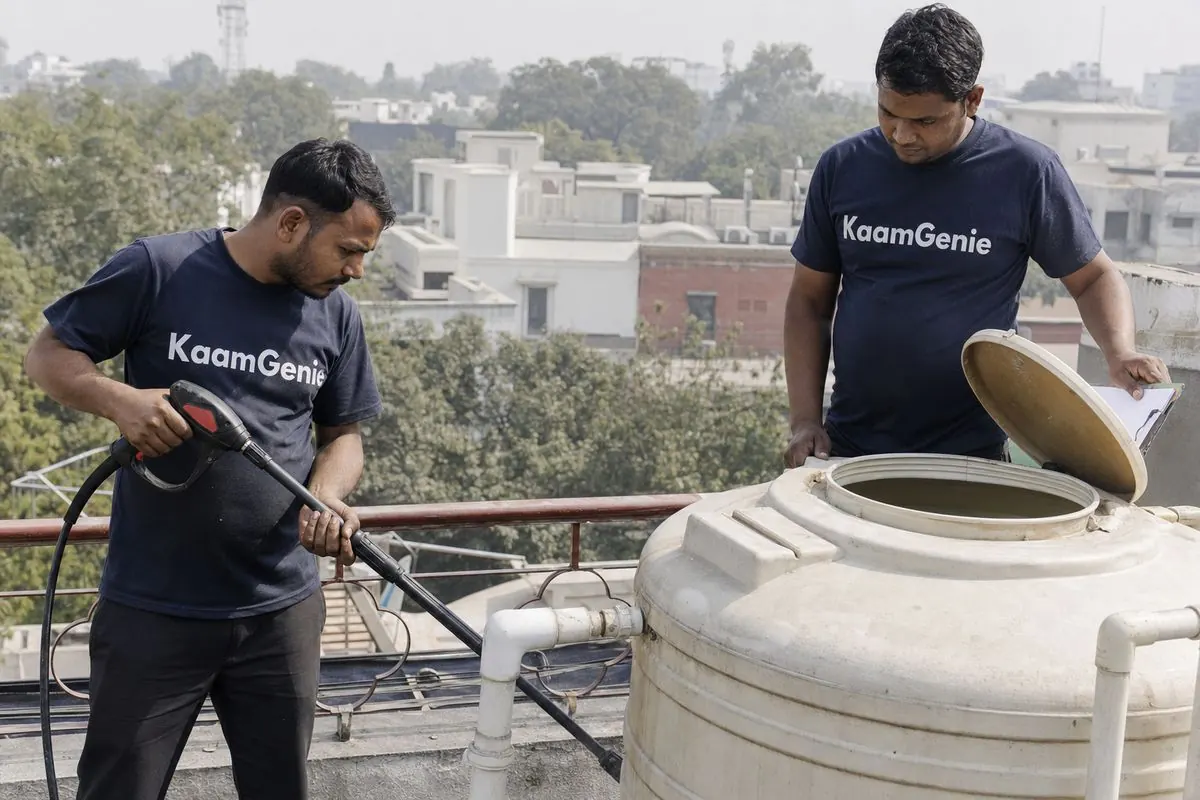 KaamGenie crew cleaning a water tank on a Central Delhi rooftop