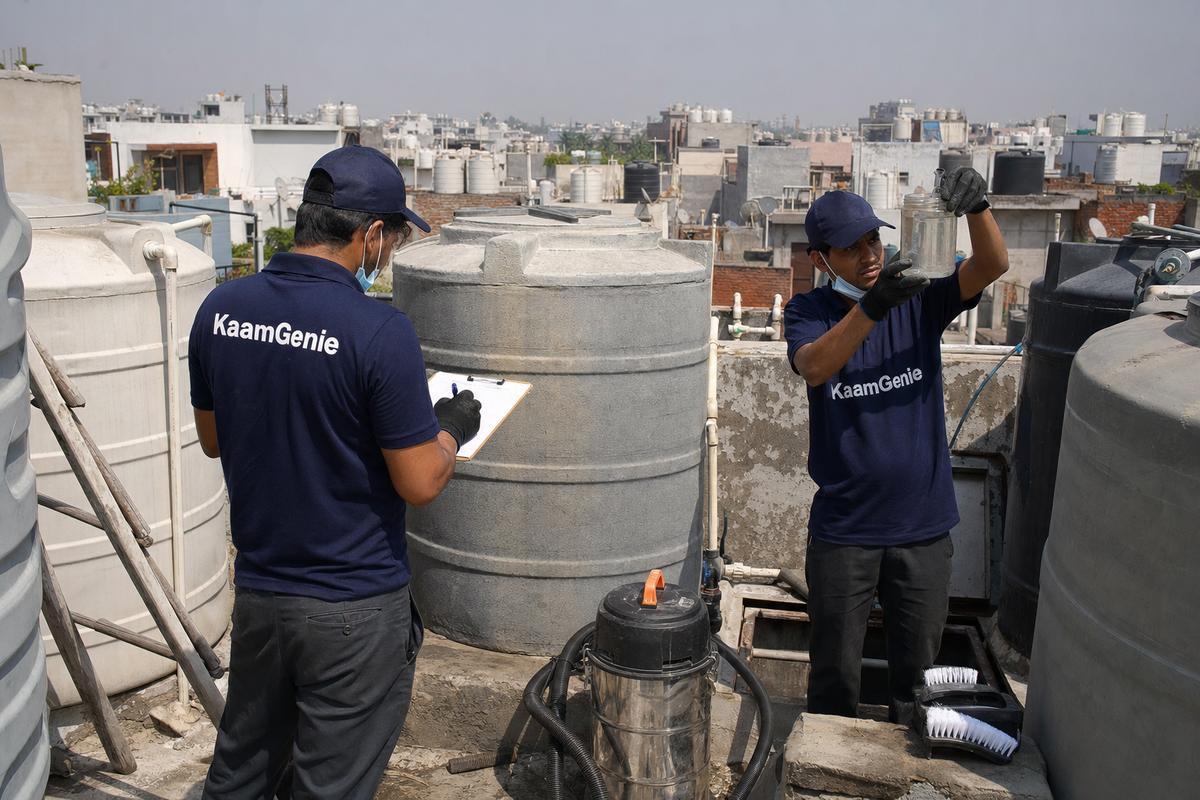 KaamGenie technicians recording water readings among rooftop tanks in Delhi