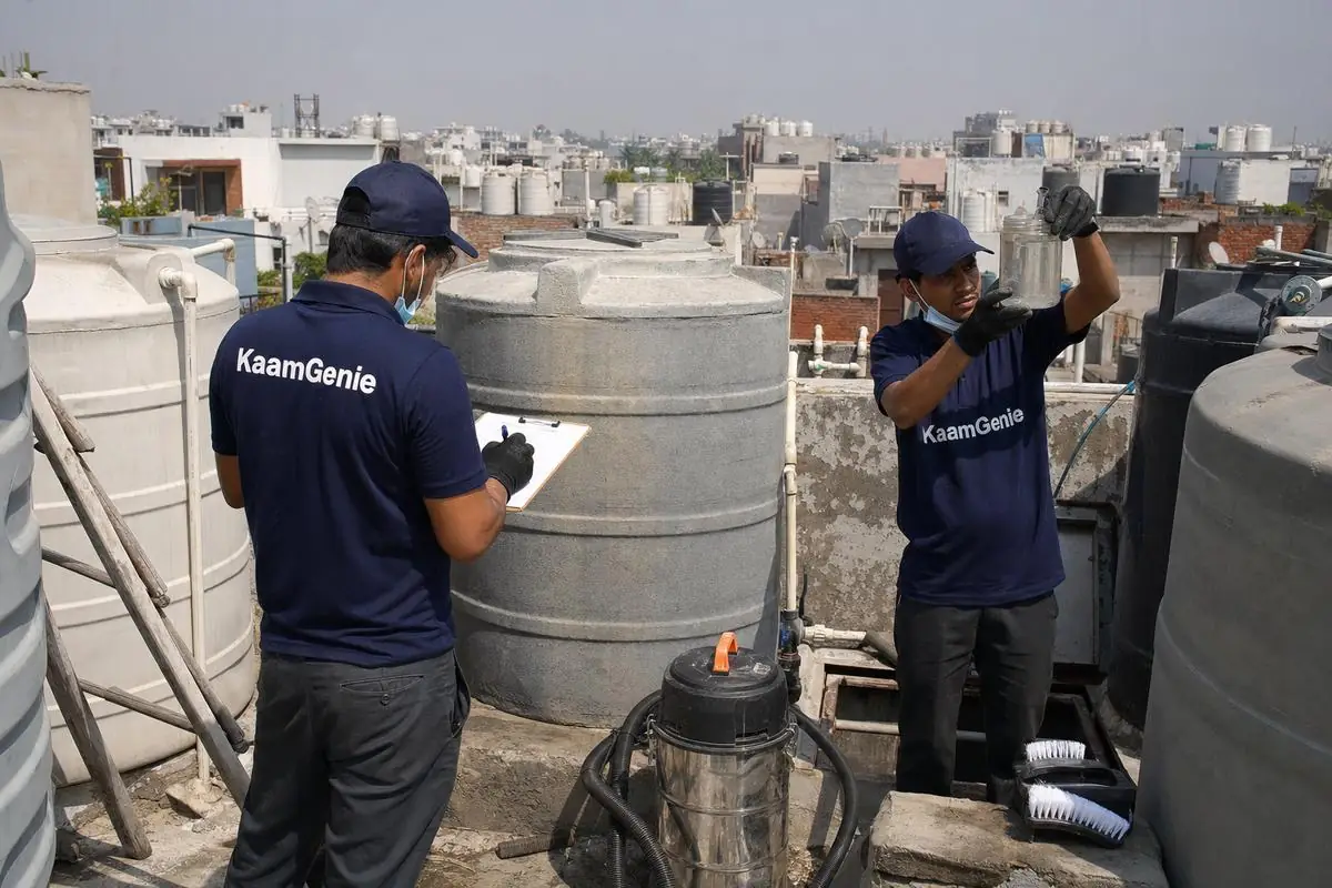 KaamGenie technicians recording water readings among rooftop tanks in Delhi