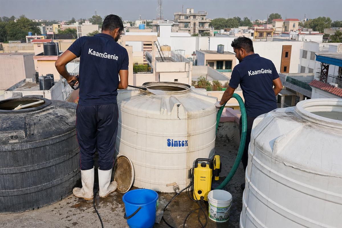KaamGenie crew cleaning a water tank in Charmwood Village, Faridabad