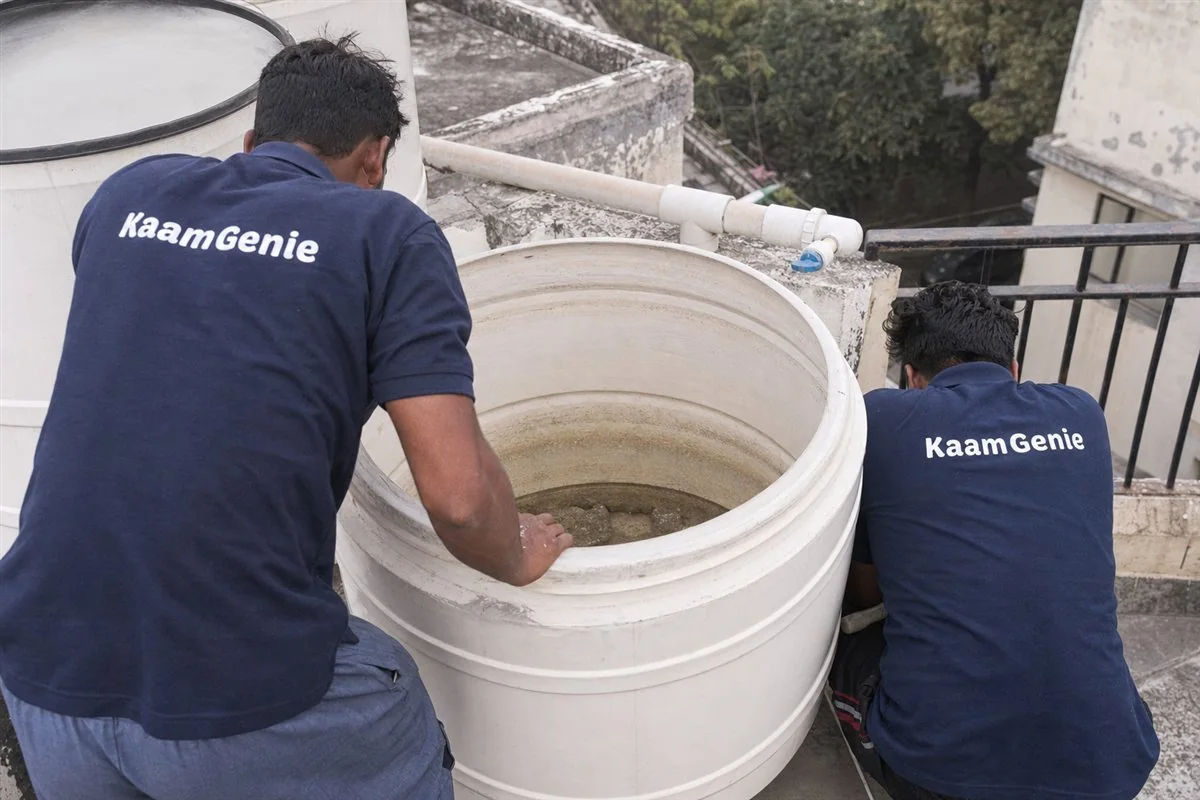 Cloudy hard-water sediment settled at the bottom of an open water tank in a Gurgaon home