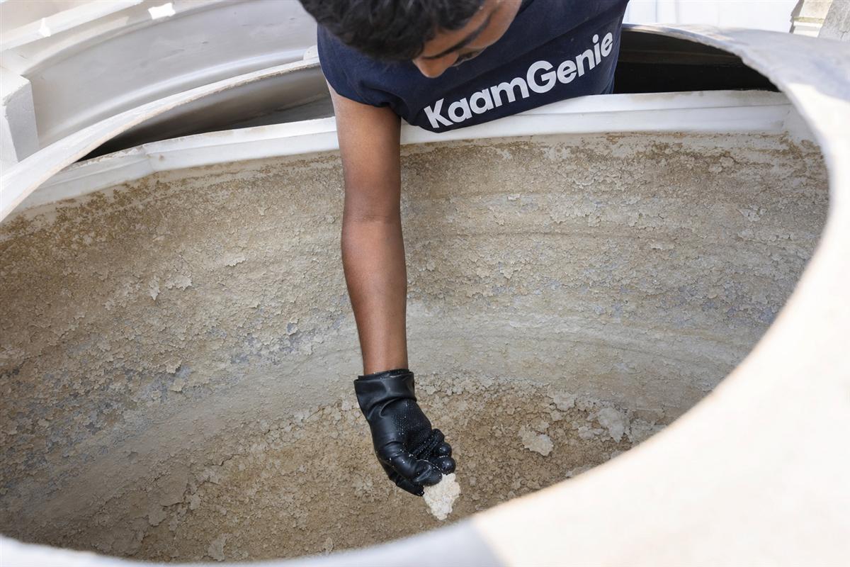 White and grey calcium scale crusted on the inside wall and floor of a Delhi water tank fed by hard borewell water