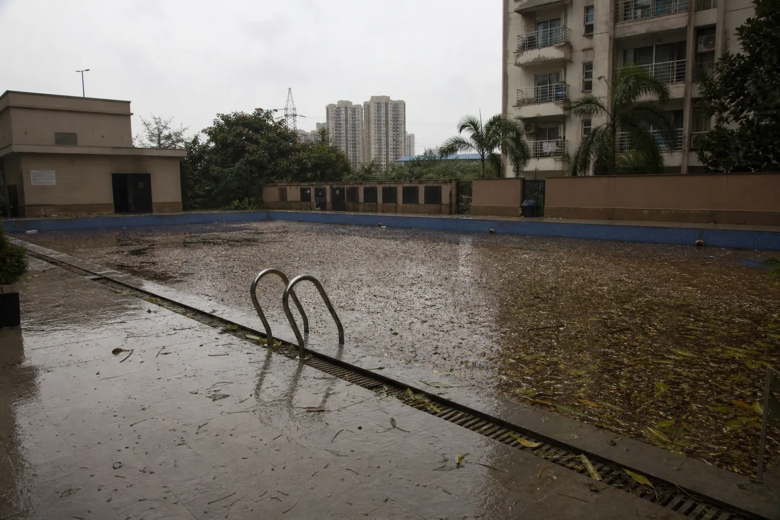 KaamGenie crew clearing monsoon debris from a swimming pool in Delhi NCR