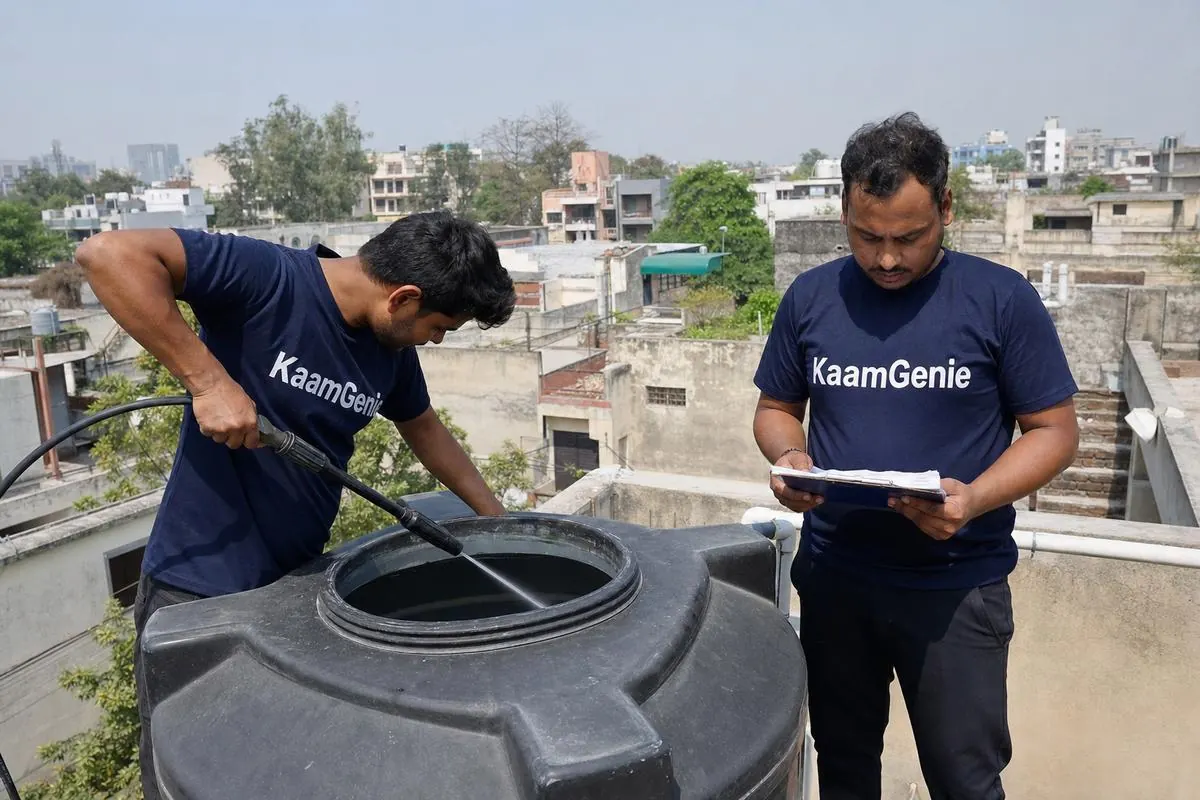KaamGenie crew cleaning a water tank on a North Delhi rooftop