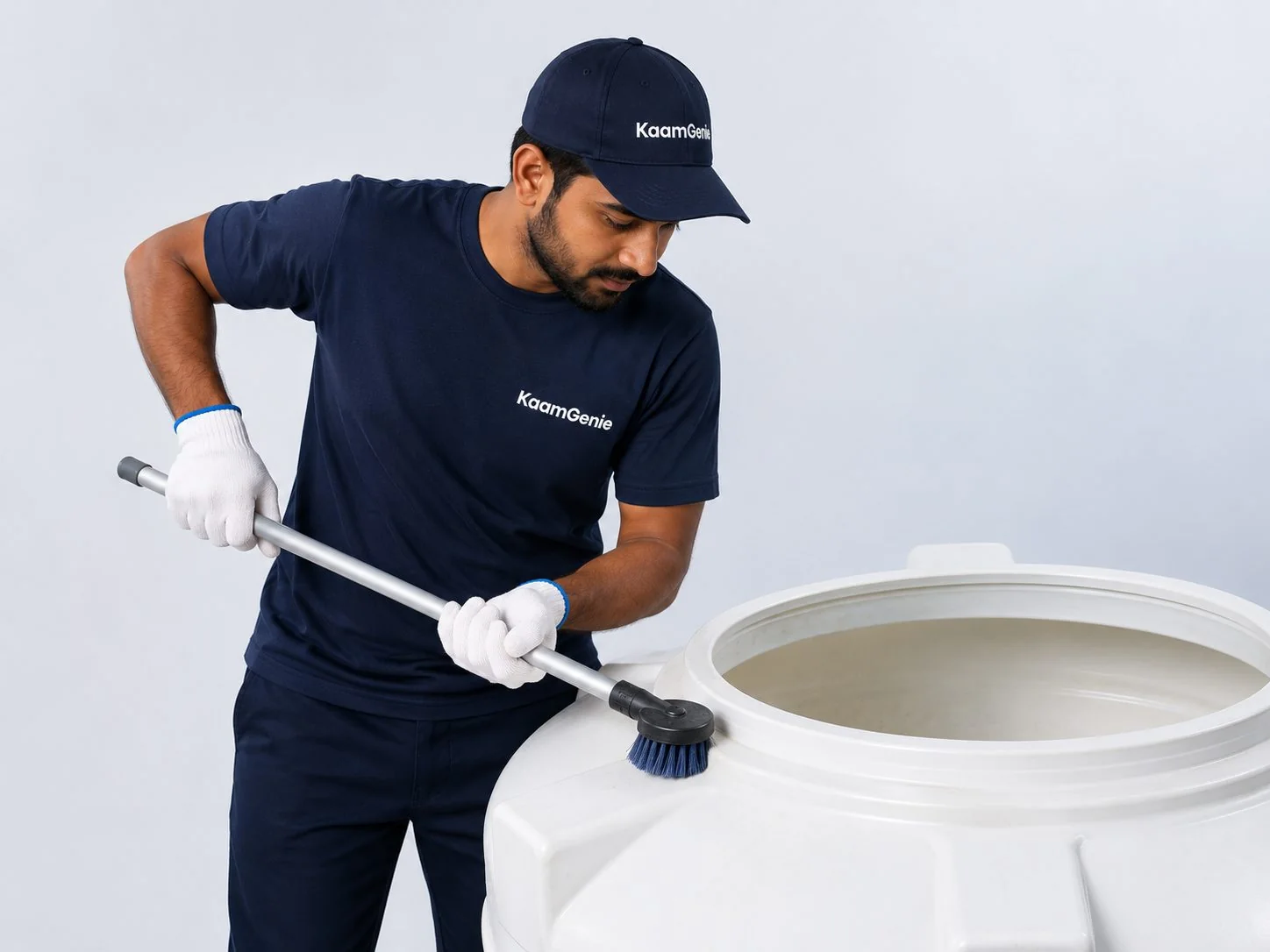 KaamGenie crew member cleaning an overhead water tank on a Delhi rooftop