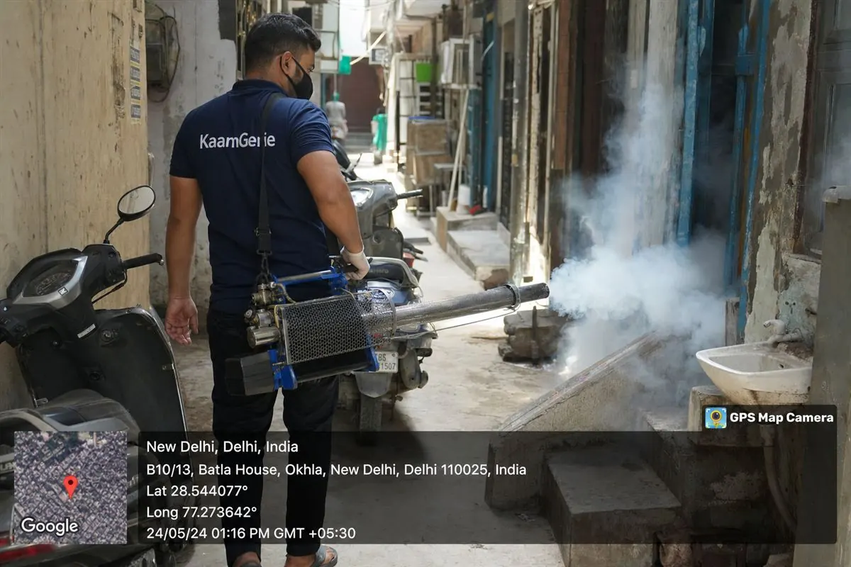 KaamGenie pest control technician fogging for mosquitoes in a narrow lane of Batla House, Okhla, South-East Delhi