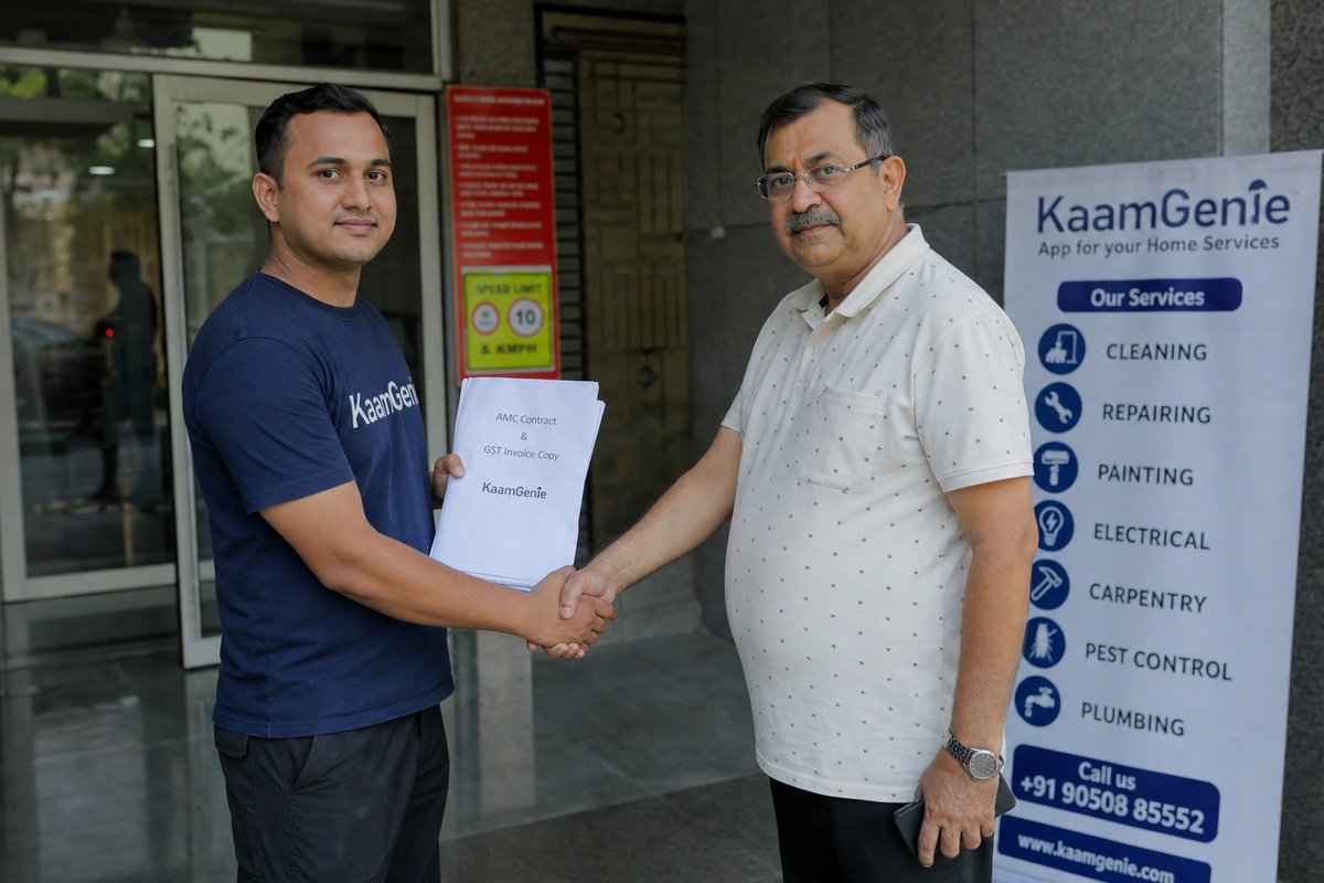 KaamGenie technician handing a printed AMC contract and GST invoice to a Delhi RWA secretary