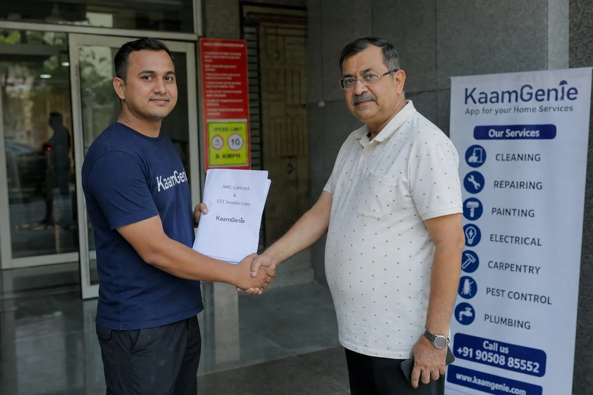 KaamGenie technician handing a printed AMC contract and GST invoice to a Delhi RWA secretary