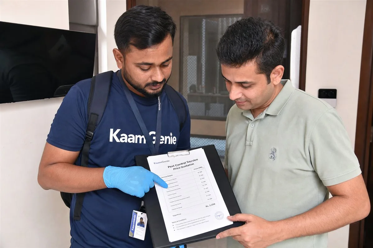 KaamGenie pest-control technician going through a treatment price list with a homeowner at a Delhi flat