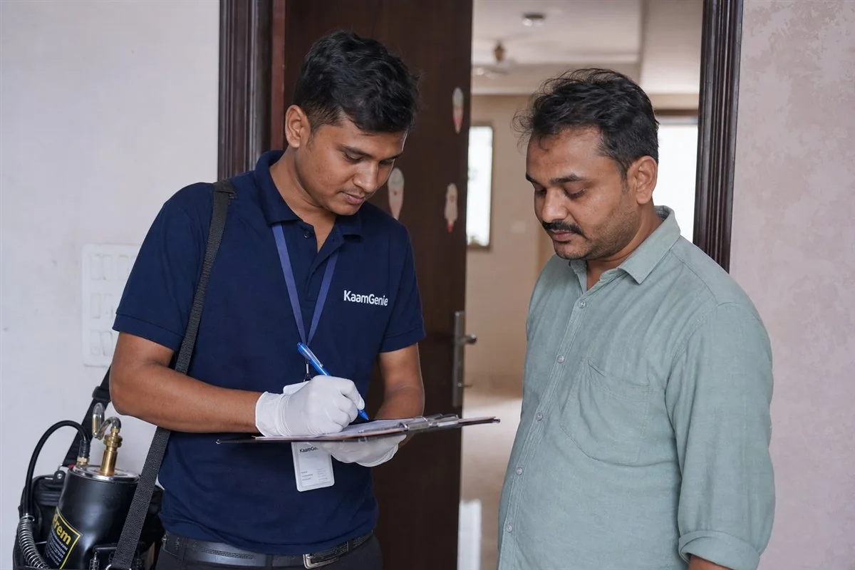 A licensed KaamGenie pest control technician with proper equipment treating a Delhi home while the resident checks the scope of work