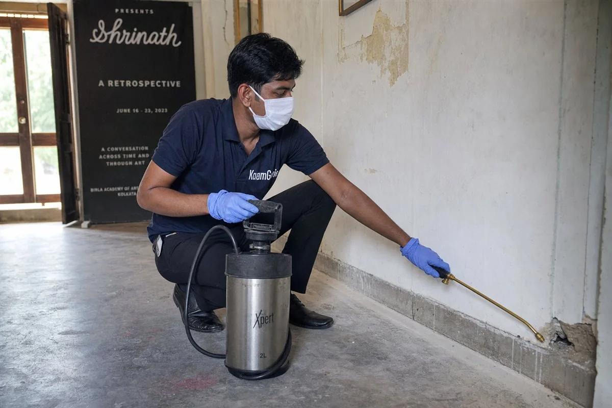 KaamGenie pest control technician treating an old village house and art gallery building for termites and rodents in Lado Sarai near Qutub, South Delhi