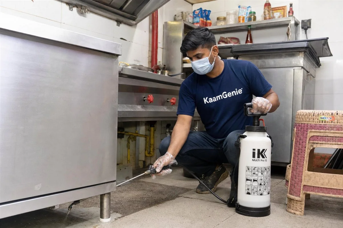 KaamGenie pest control technician treating a Laxmi Nagar Extension property in East Delhi