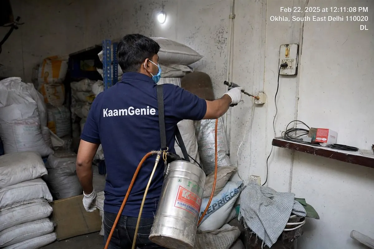 KaamGenie pest control technician treating a mixed industrial and residential building in Okhla Phase 3, South-East Delhi