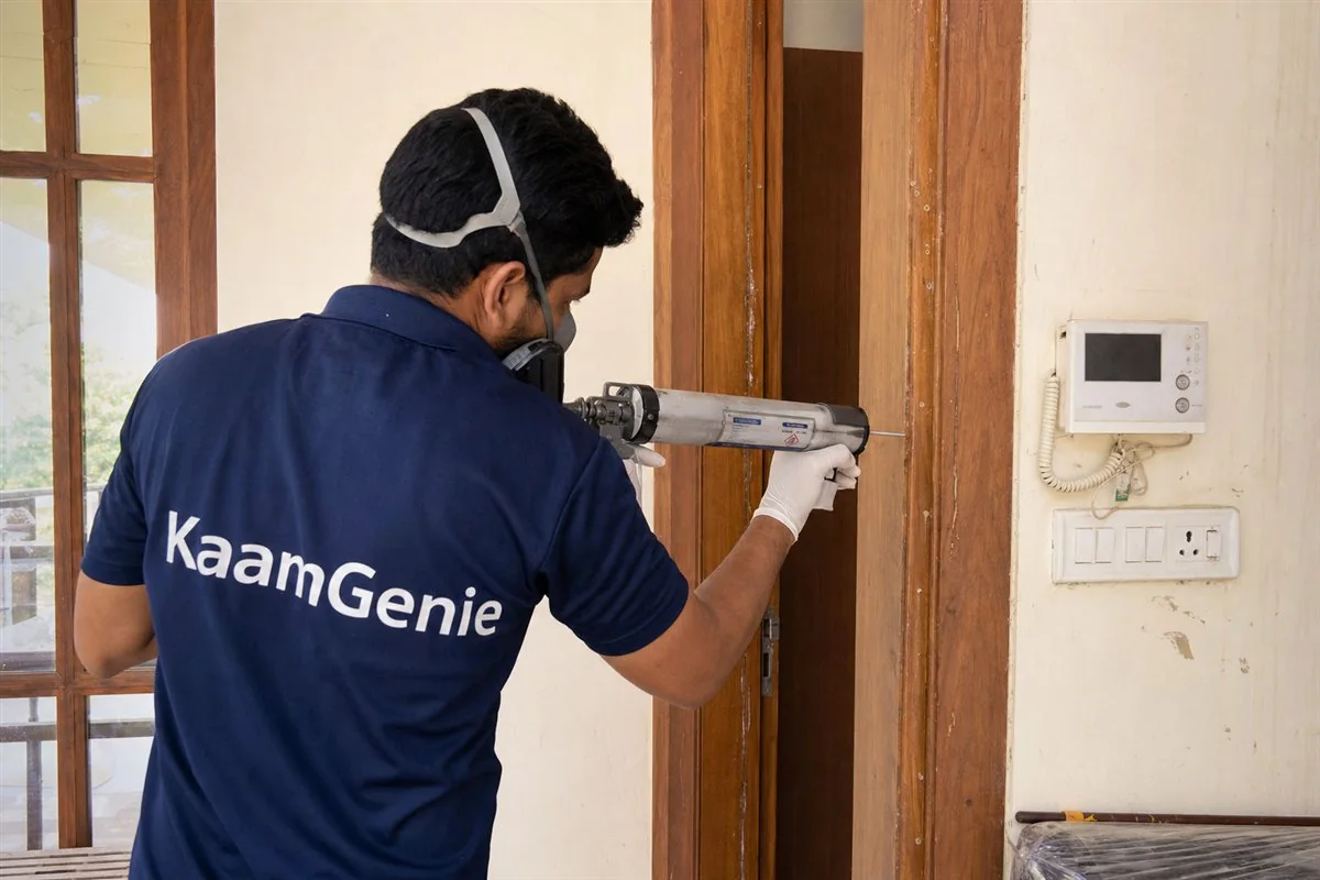 KaamGenie pest control technician injecting anti-termite chemical into old government-quarter woodwork in RK Puram, South Delhi