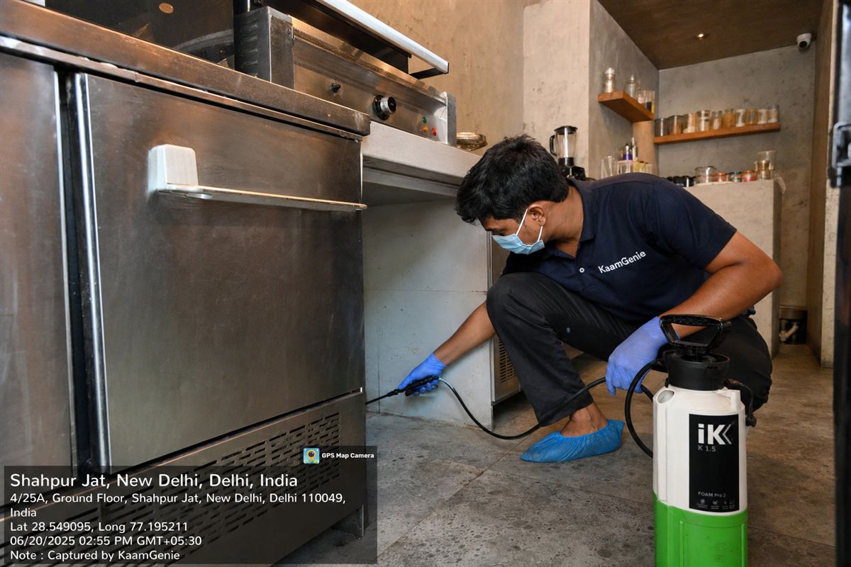 KaamGenie pest control technician treating a boutique-cafe in Shahpur Jat, near Hauz Khas, South Delhi