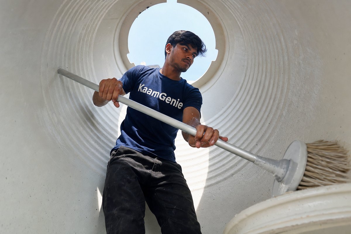 KaamGenie crew inspecting a concrete water tank wall in a Delhi home for hairline cracks and waterproofing layer flaking