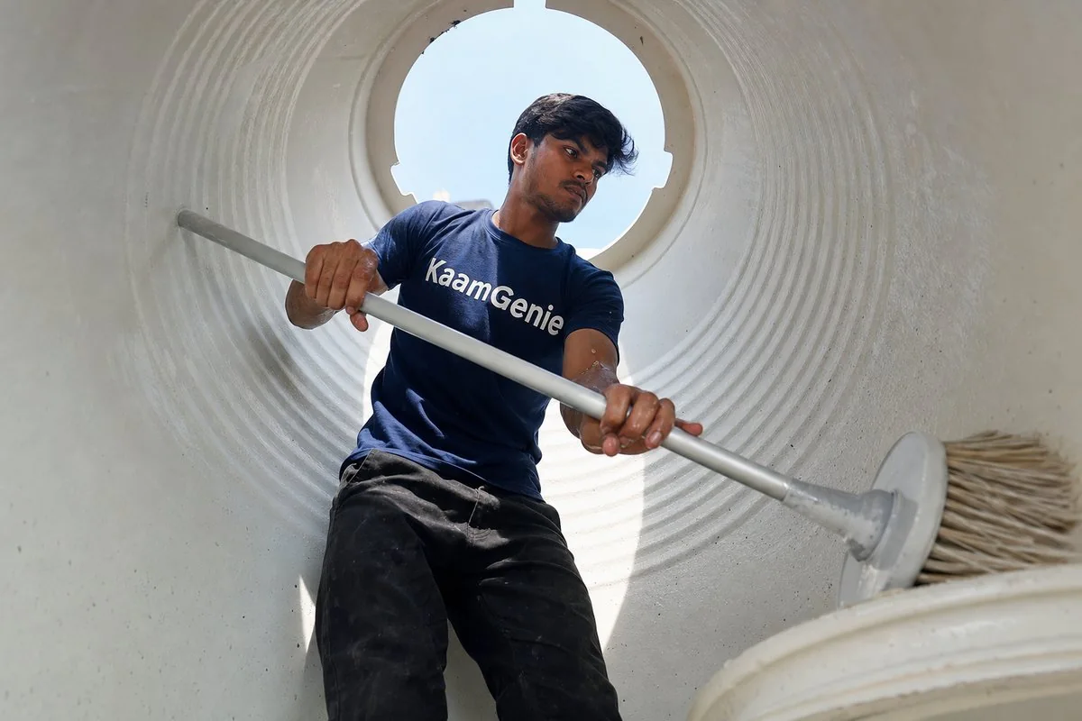 KaamGenie crew inspecting a concrete water tank wall in a Delhi home for hairline cracks and waterproofing layer flaking