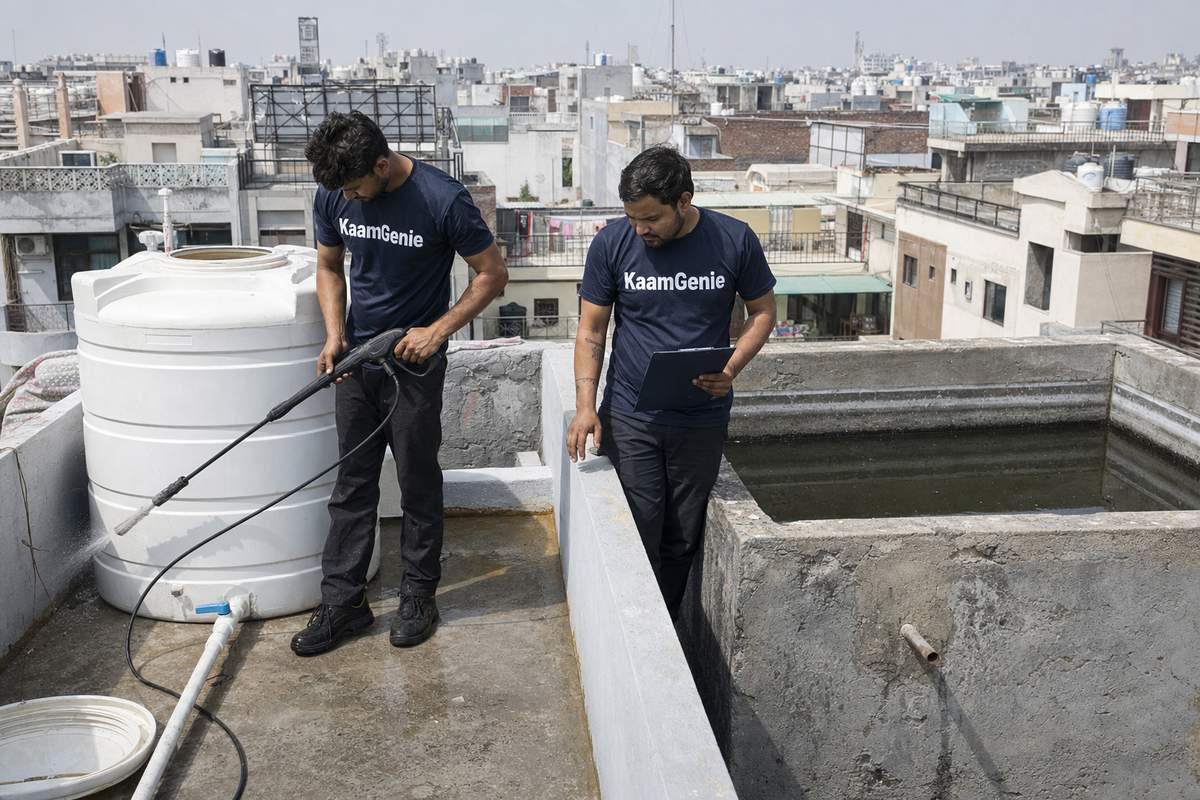 Side-by-side Delhi rooftop showing a plastic overhead water tank and a concrete RCC water tank for material comparison