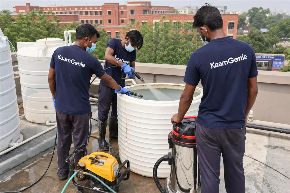 KaamGenie crew cleaning rooftop water tanks at a Delhi school during the holidays with the campus empty