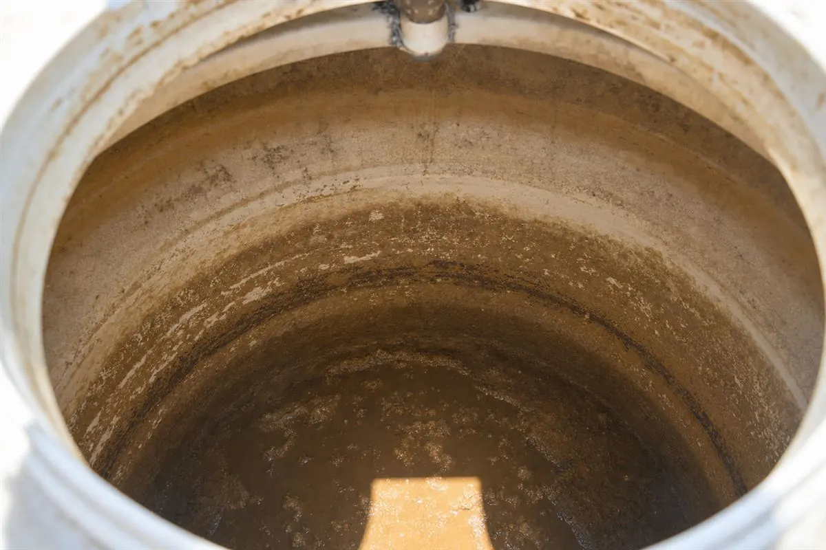 Close-up of white chalky limescale crusted on the rim and float valve of a plastic water tank in a Gurgaon home