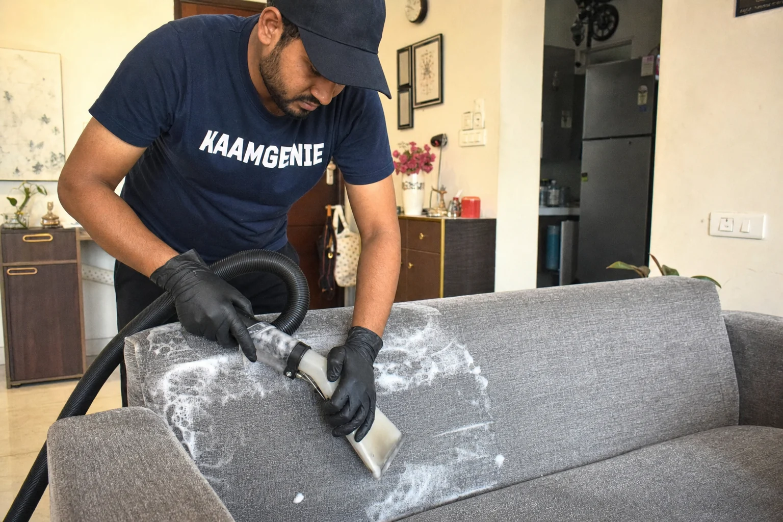 KaamGenie crew doing fabric sofa cleaning at a Delhi NCR home