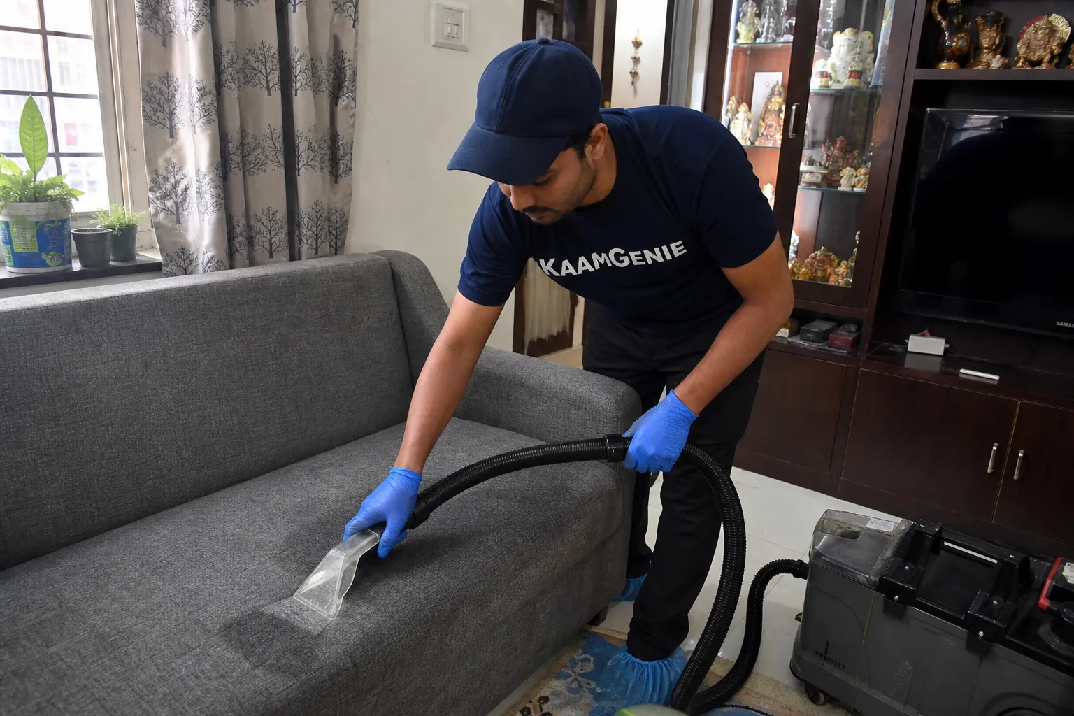KaamGenie crew cleaning a fabric sofa at a Rajouri Garden home in Delhi