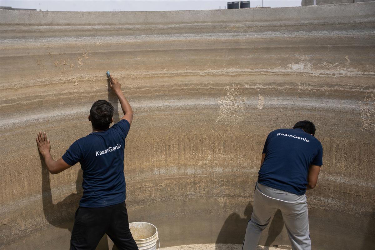 Hard-water scale and dried sediment baked onto the dry interior wall of a Delhi water tank during summer