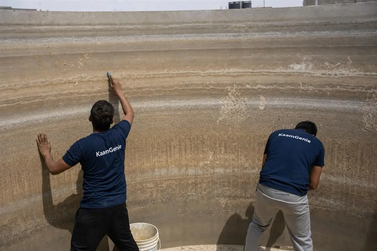 Hard-water scale and dried sediment baked onto the dry interior wall of a Delhi water tank during summer