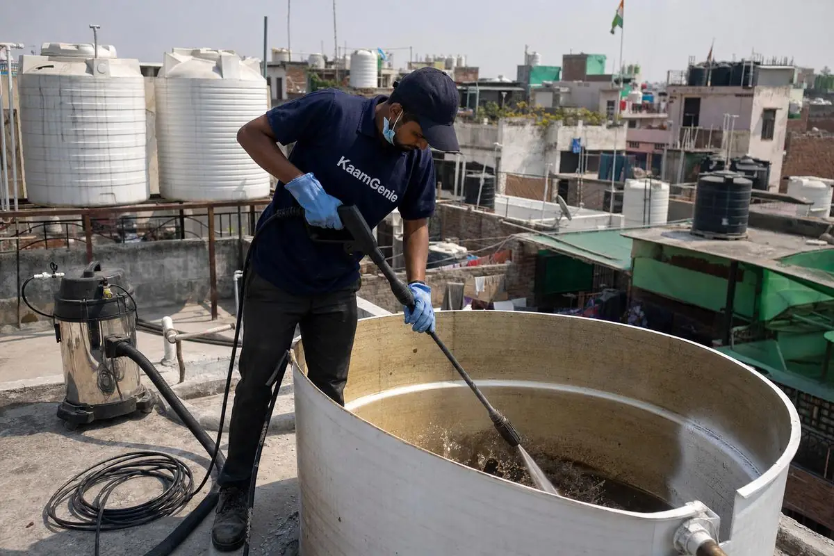 KaamGenie crew cleaning a overhead (rooftop) tank in Ambedkar Nagar, Delhi
