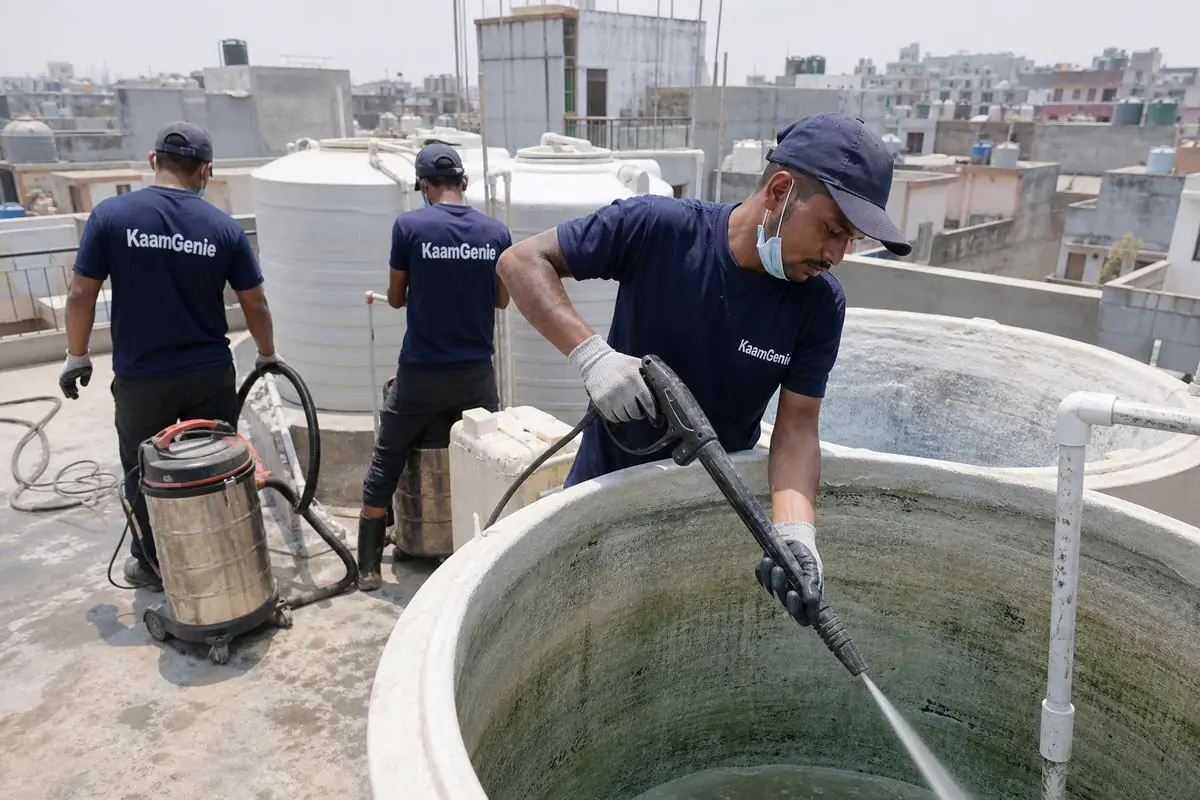 KaamGenie crew cleaning a overhead (rooftop) tank in Bharat Nagar, Delhi