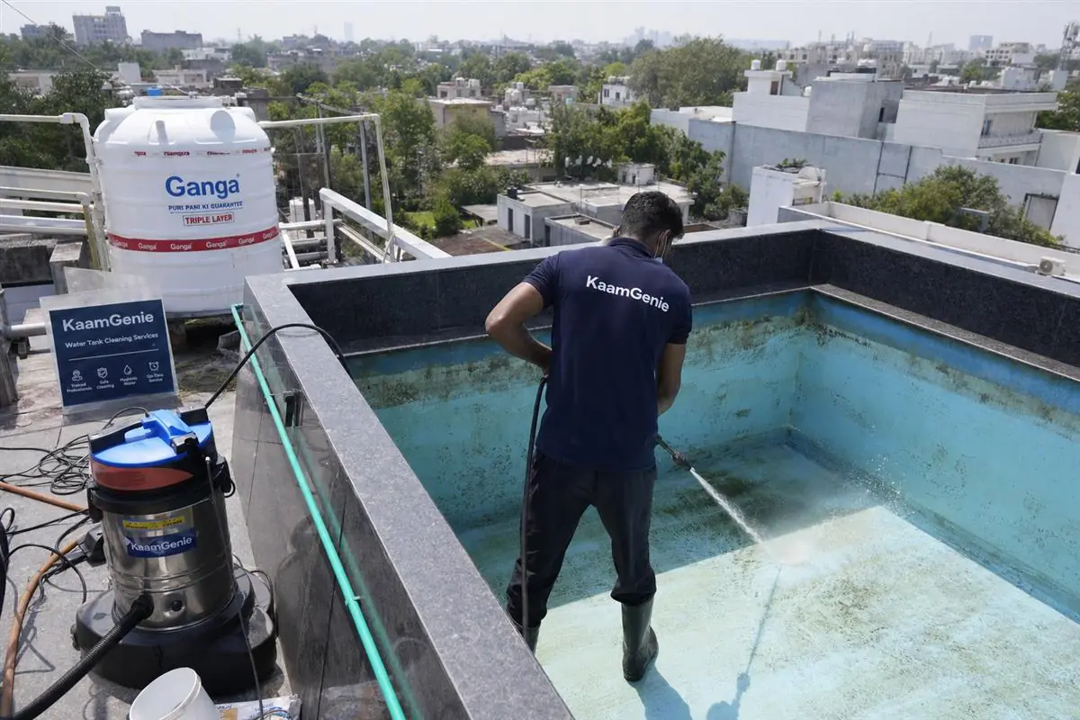 KaamGenie crew cleaning a overhead (rooftop) tank in Chattarpur, Delhi
