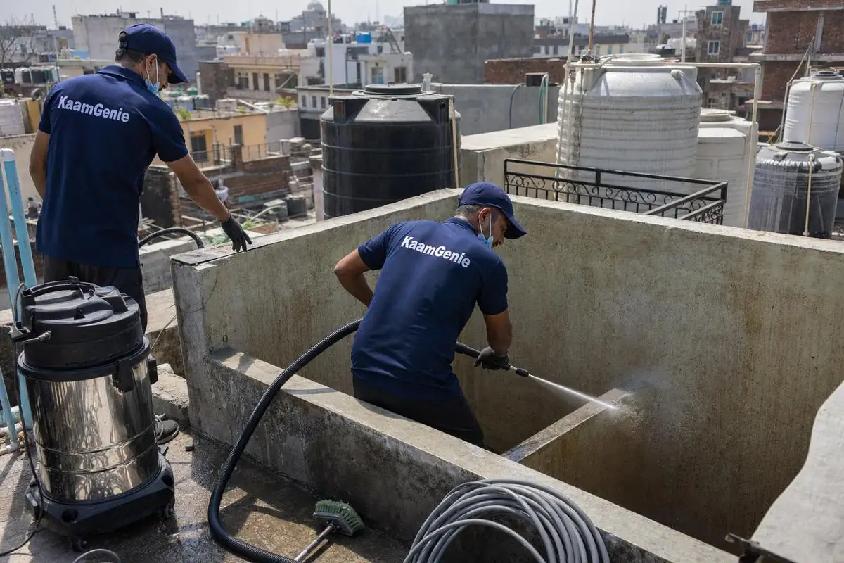 KaamGenie crew cleaning a overhead (rooftop) tank in Deoli, Delhi