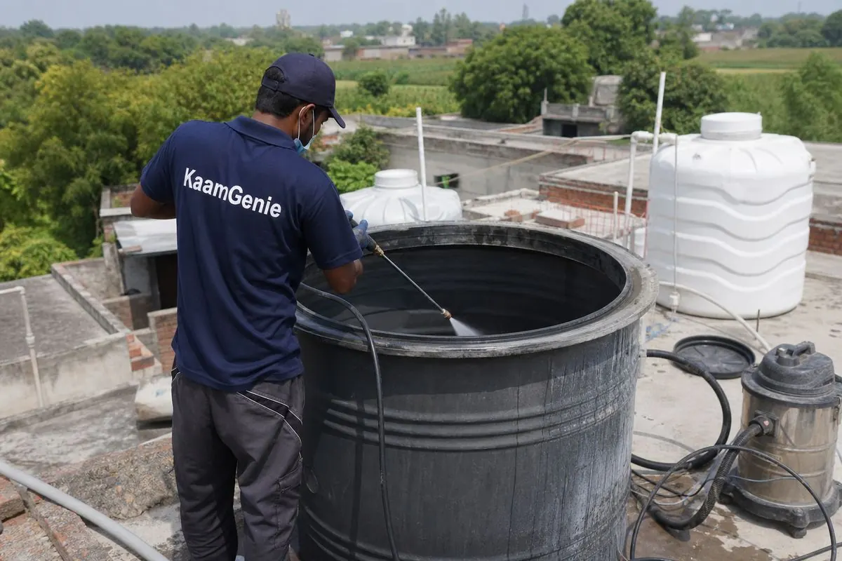 KaamGenie crew cleaning a overhead (rooftop) tank in Fatehpur Beri, Delhi