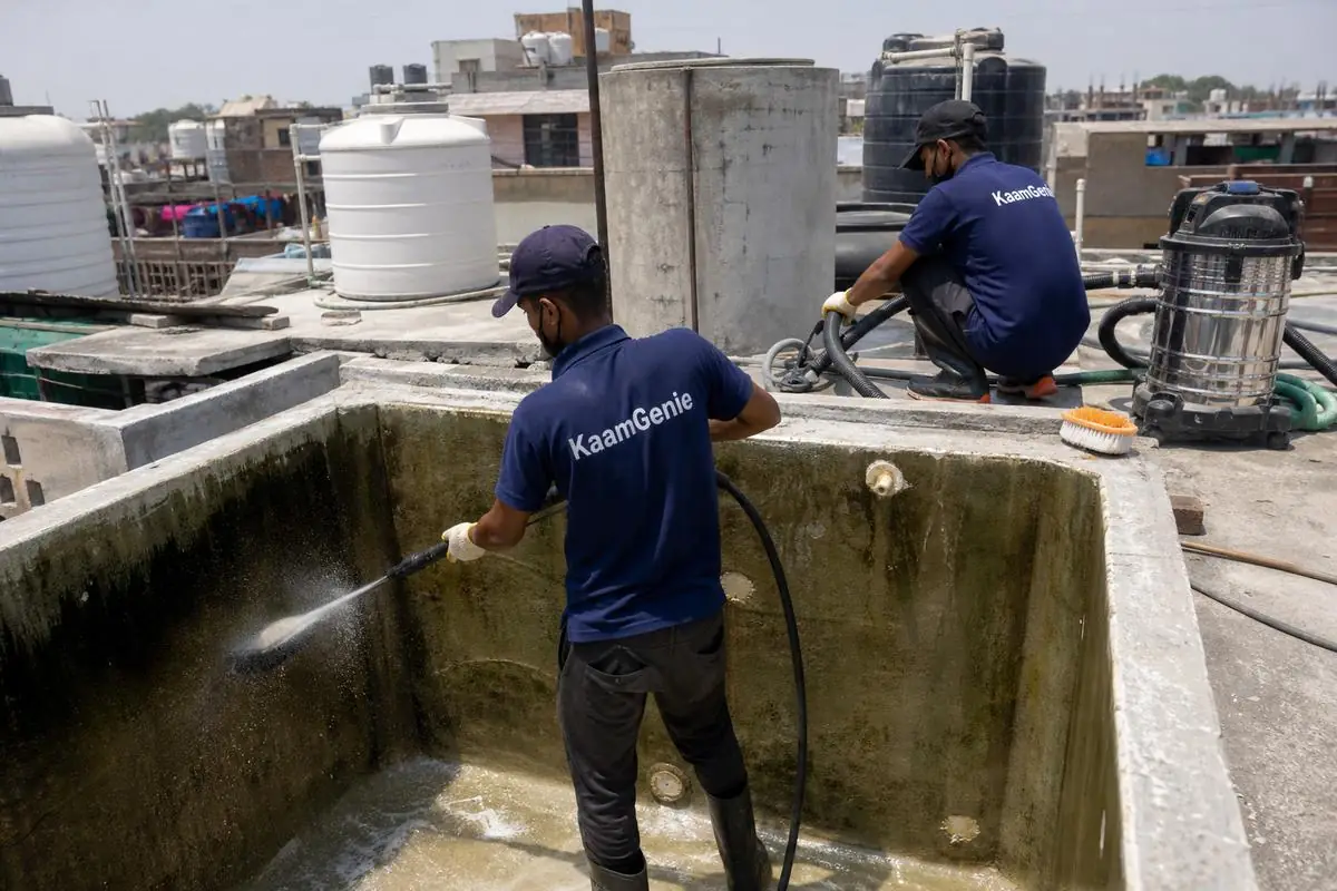 KaamGenie crew cleaning a overhead (rooftop) tank in Gandhi Nagar Bazar, Delhi