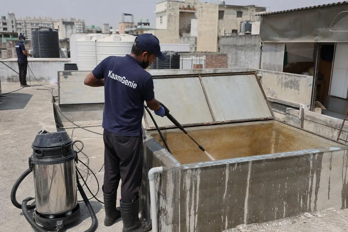 KaamGenie crew cleaning a overhead (rooftop) tank in Garhi, Delhi