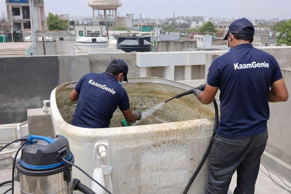 KaamGenie crew cleaning a overhead (rooftop) tank in Haiderpur, Delhi
