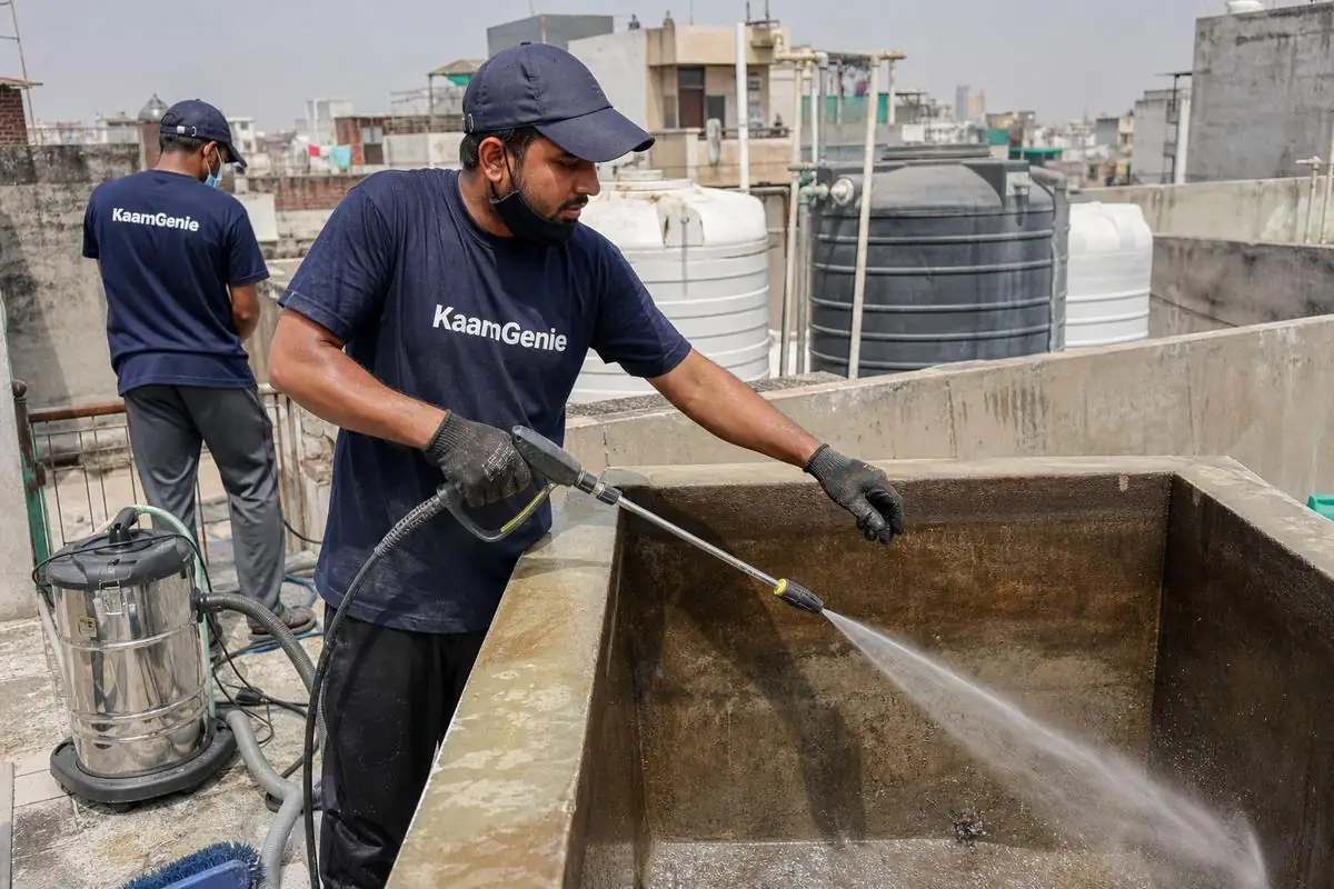 KaamGenie crew cleaning a overhead (rooftop) tank in Hari Nagar Ashram, Delhi
