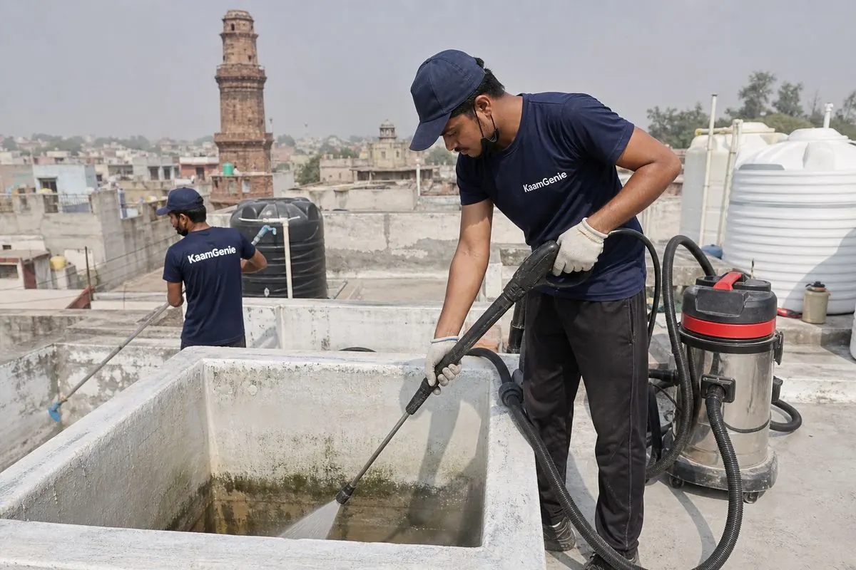 KaamGenie crew cleaning a overhead (rooftop) tank in Hastsal, Delhi