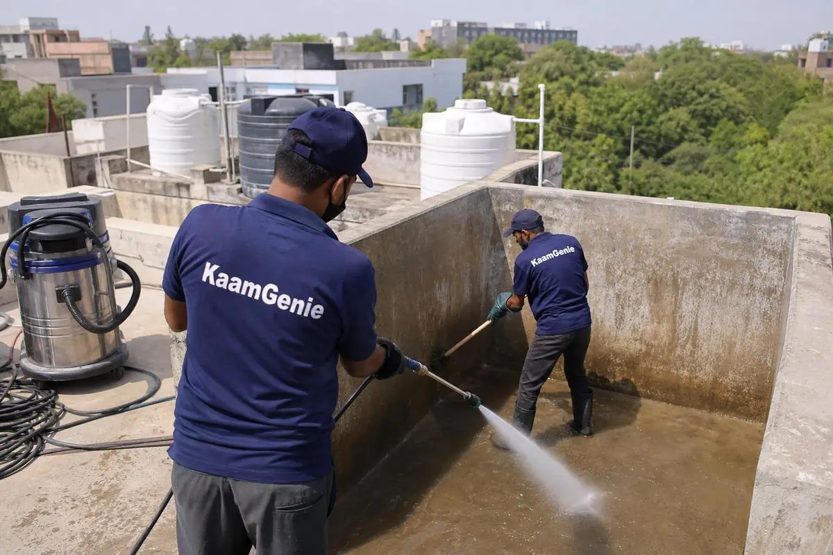 KaamGenie crew cleaning a overhead (rooftop) tank in Ishwar Nagar, Delhi