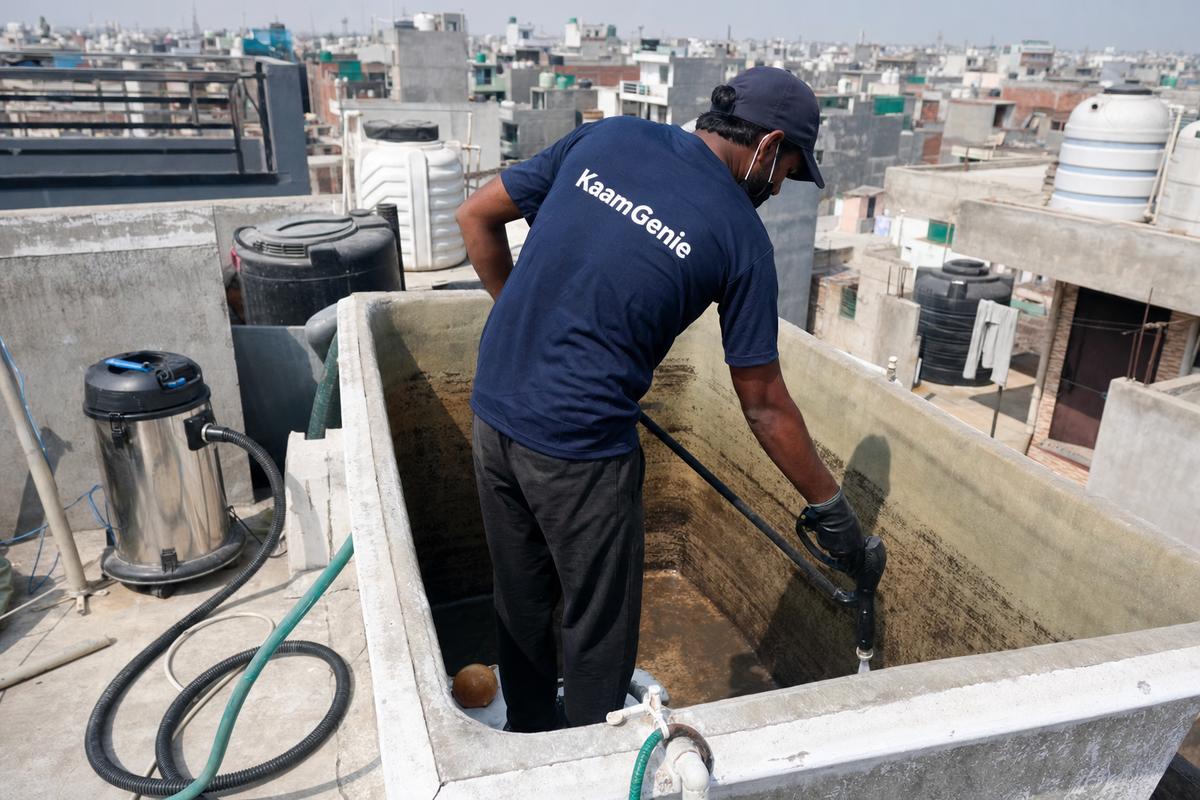 KaamGenie crew cleaning a overhead (rooftop) tank in Jaitpur, Delhi
