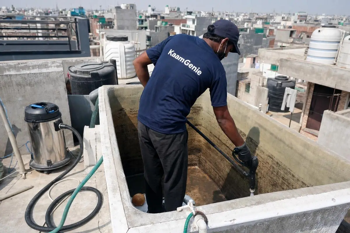 KaamGenie crew cleaning a overhead (rooftop) tank in Jaitpur, Delhi