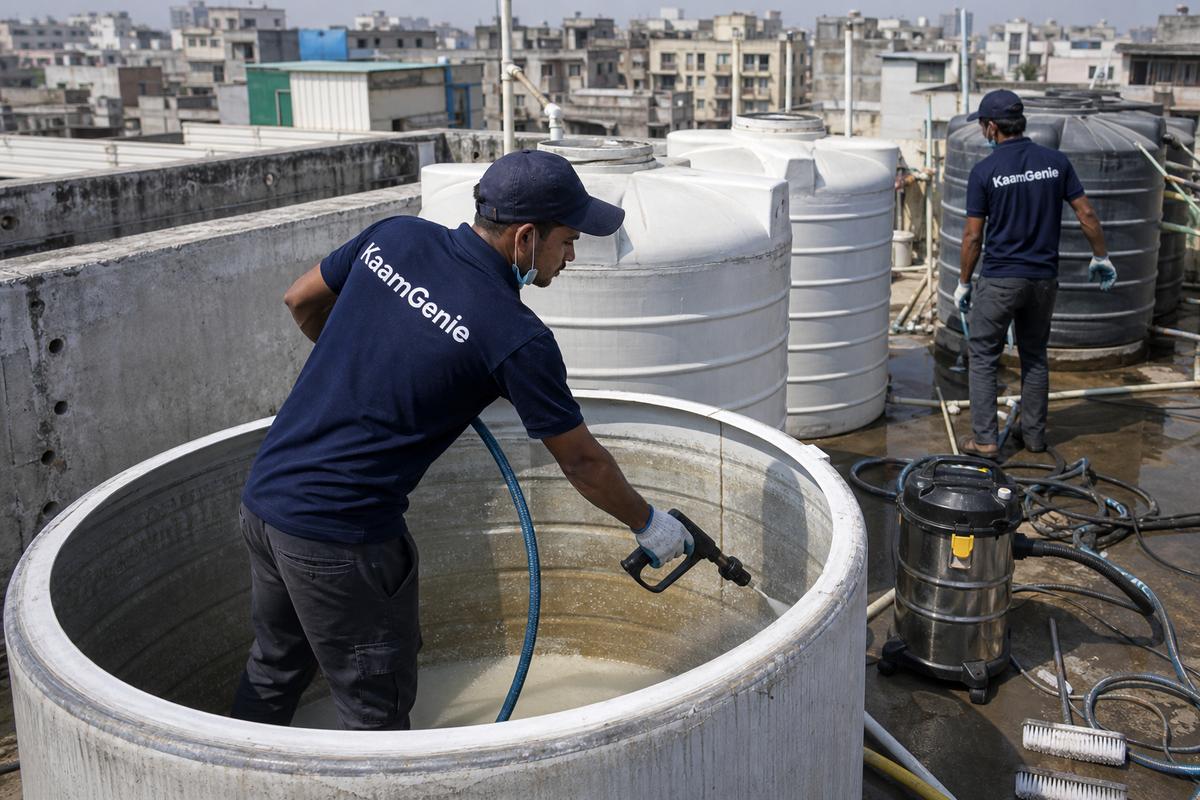 KaamGenie crew cleaning a overhead (rooftop) tank in Johri Farm, Delhi