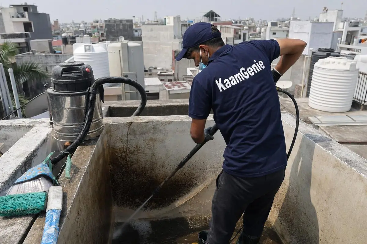 KaamGenie crew cleaning a overhead (rooftop) tank in Kasturba Nagar, Delhi