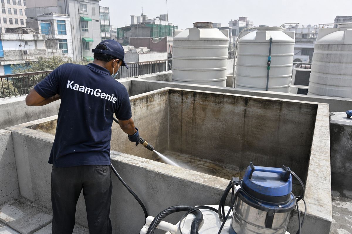 KaamGenie crew cleaning a overhead (rooftop) tank in Khan Market, Delhi