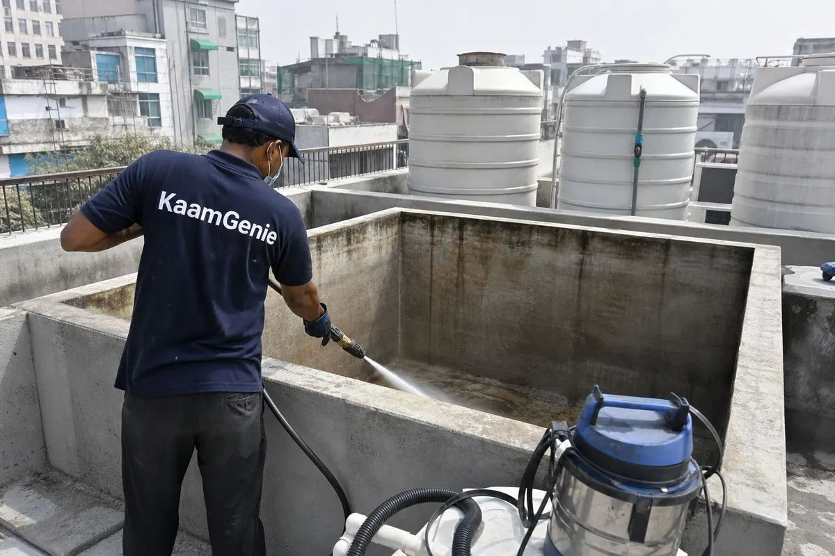 KaamGenie crew cleaning a overhead (rooftop) tank in Khan Market, Delhi